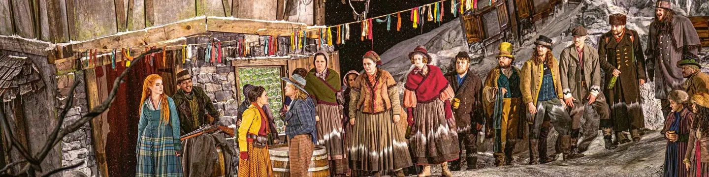 Gruppenbild mit vielen Kostümen auf der Seebühne mit alten Häusern im Hintergrund