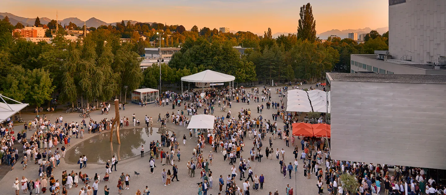 © Bregenzer Festspiele / Anja Köhler Ambiente Vorplatz bei Sonnenuntergang, viele Personen versammeln sich am Vorplatz um später die Madame Butterfly, das Spiel auf dem See zu besuchen