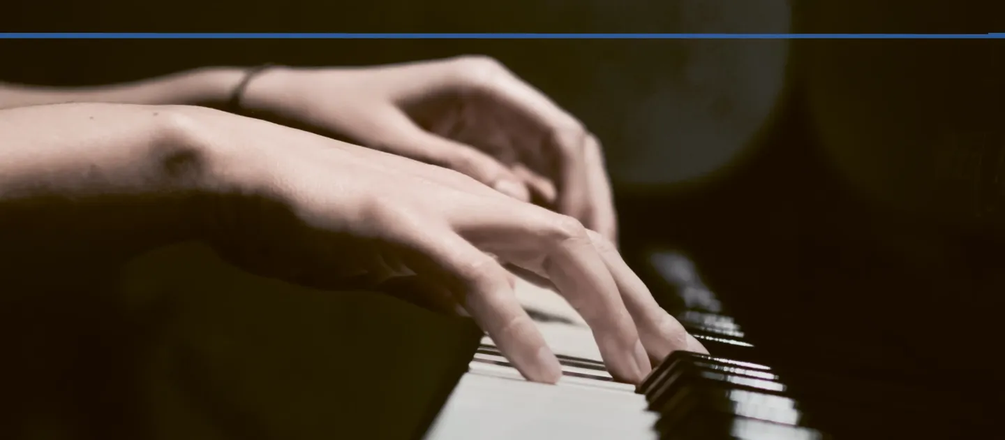 © Bregenzer Festspiele Detailaufnahme von Händen an einem Klavier mit dunklem Hintergrund