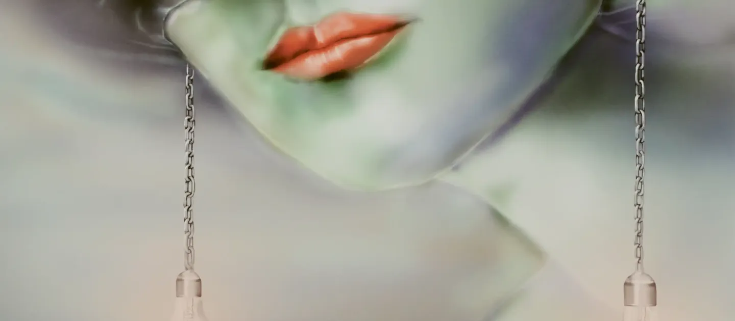 Nahaufnahme eines Gesichts mit grüner Haut und roten Lippen, an beiden Seiten hängen Glühbirnen an Ketten