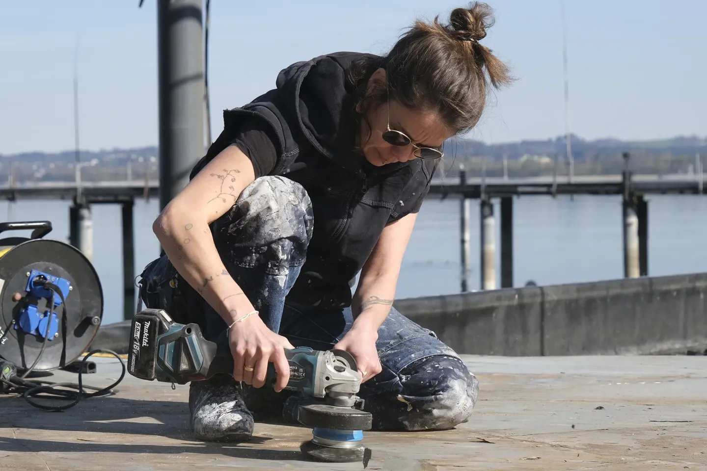 Frühjahrsputz auf der Seebühne Frühjahrsputz auf der Seebühne, Mitarbeiterin schleift Holzfläche