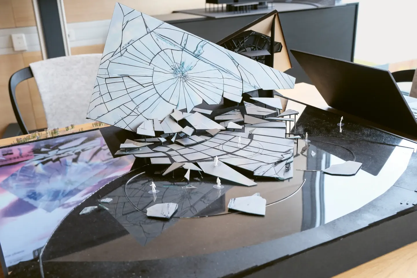 © Bregenzer Festspiele / Eva Cerv Bühnenmodell mit zerbrochenen, wirkenden Spiegel-Elementen und kleinen weißen Figuren auf schwarzer Grundfläche.