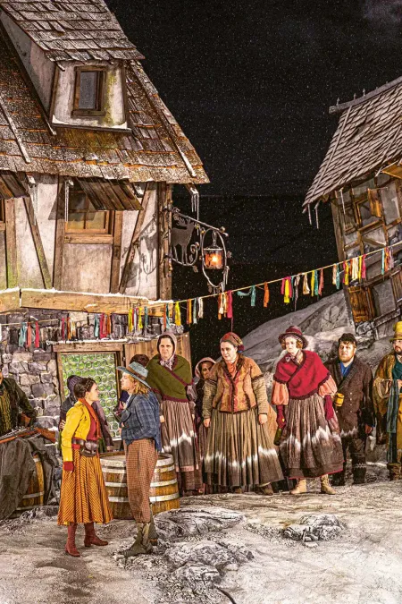 Gruppenbild mit vielen Kostümen auf der Seebühne mit alten Häusern im Hintergrund