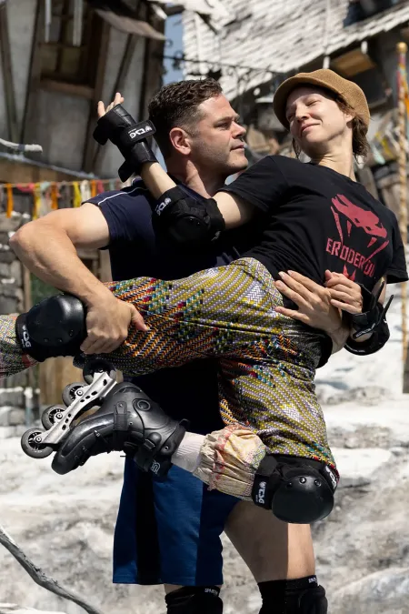 Mann und Frau auf Inlineskates machen eine Hebefigur im Bühnenbild "Der Freischütz" 