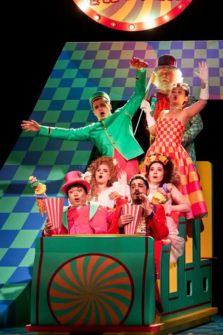 © Bregenzer Festspiele / Anja Köhler Ensemble in einem Rummelwagen, Popcorn fliegt durch die Luft.