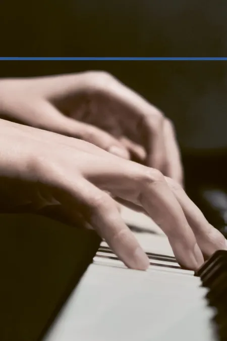 © Bregenzer Festspiele Detailaufnahme von Händen an einem Klavier mit dunklem Hintergrund