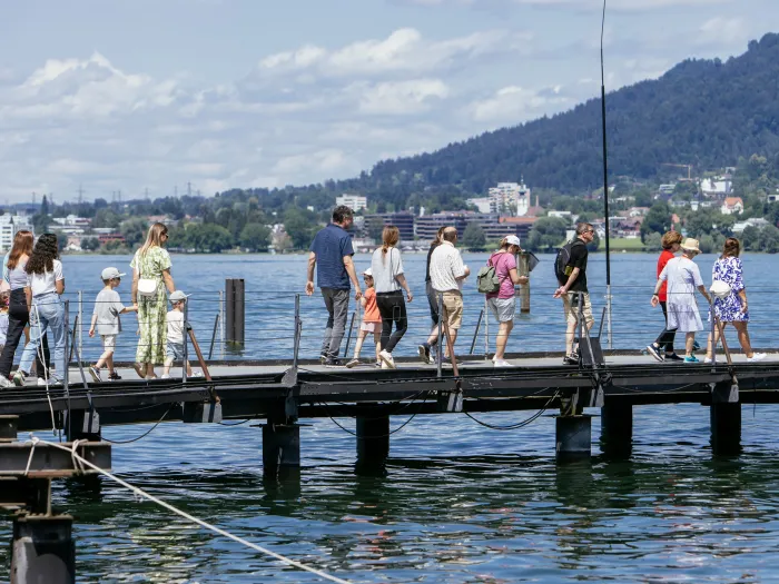 Festspielführung: Eine Gruppe geht über den Steg zur Seebühne