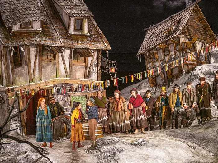 Gruppenbild mit vielen Kostümen auf der Seebühne mit alten Häusern im Hintergrund