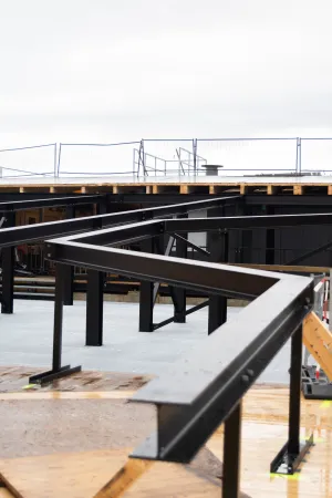 Stahl-Holz-Konstruktion mit schwarzen Stahlträgern und Holzbohlen auf einer Baustelle